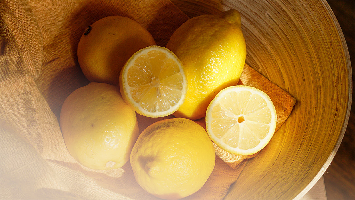 Zitronen auf Leinentuch in Holzschale warmes Licht